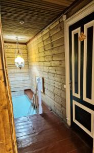 une baignoire jacuzzi dans une chambre avec des murs en bois dans l'établissement Skiemonių Dvaras, à Skiemonys