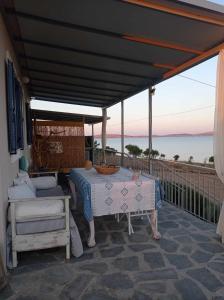 a bed and a table on a balcony with the ocean at Seaside resort- kallithea in Kallithéa