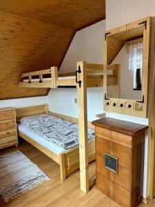 a bedroom with two bunk beds and a table at Privát NA CHALUPE Partizánska Ľupča 649 in Partizánska ľupča