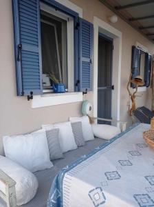 a porch with pillows and a bed on a balcony at Seaside resort- kallithea in Kallithéa