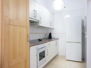 a kitchen with white cabinets and a white refrigerator at Trip Puertito Pescadores in Puertito de Güímar