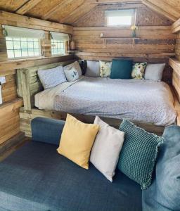 a bedroom with a bed and a couch in a cabin at Moon Valley Glamping 
