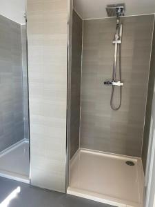 a shower with a glass door in a bathroom at Moon Valley Glamping 