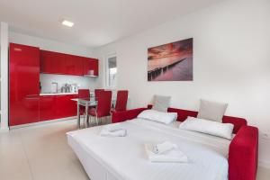 a bedroom with a white bed and red cabinets at Residences Bellavista 3 in Novalja