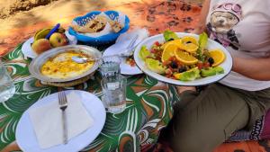 einen Tisch mit Teller mit Lebensmitteln darüber in der Unterkunft Visitors camp in M’hamid El Ghizlane