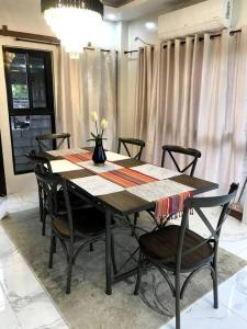 una mesa de comedor con sillas y un jarrón con flores en Rainiers Private Resort house has 2 rooms 2 huts total of 5 rooms, 