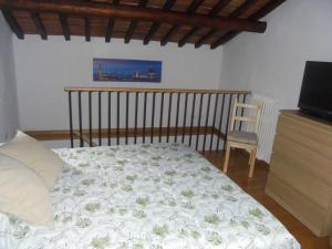 1 dormitorio con 1 cama, TV y silla en CASA GIOIA, en Greve in Chianti