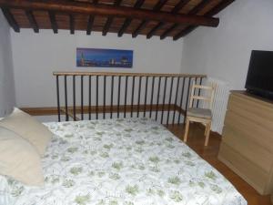 a bedroom with a bed and a tv and a chair at CASA GIOIA in Greve in Chianti