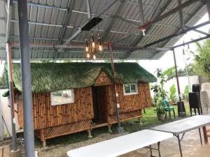 a hut with a roof with a table and a chandelier at Rainiers Private Resort house has 2 rooms 2 huts total of 5 rooms 