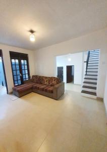 a living room with a couch and a staircase at Orchard Home in Kandy