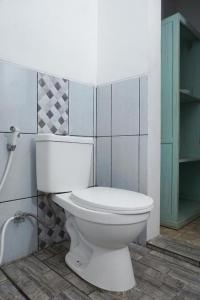 a bathroom with a white toilet in a room at RedDoorz at Griya Cemara Homestay Yogyakarta in Yogyakarta