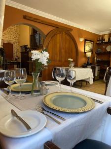 a table with a plate and wine glasses on it at La Dolce Vita Guest House in Hartbeespoort