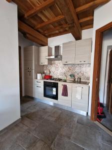 cocina con armarios blancos y suelo de baldosa en Casa Il Girasole, en Lugnano in Teverina
