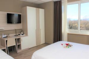 Pokój hotelowy z łóżkiem, biurkiem i telewizorem w obiekcie Best Quality Hotel La Darsena w mieście Moncalieri