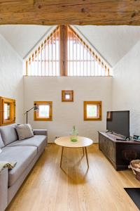 uma sala de estar com um sofá e uma mesa em dieKELLERSTÖCKL - Das Rosenstöckl S22 mit Mini-Pool em Stainz