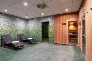 una sala de espera con 2 sillas y papel pintado verde en Crowne Plaza Antwerpen, an IHG Hotel en Amberes