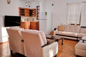 Villa Kaktus 2 في كاس: غرفة معيشة مع كنبتين وتلفزيون