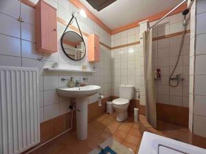 ein Badezimmer mit einem Waschbecken, einem WC und einem Spiegel in der Unterkunft YourLittleMiracle-PanoramicView+FirePit+Garden+BBQ in Argalasti