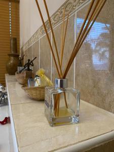 a glass vase with sticks in it on a counter at La Dolce Vita Guest House in Hartbeespoort +42 photos