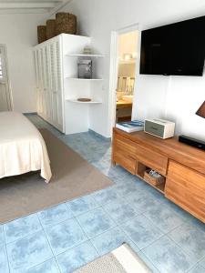 a bedroom with a flat screen tv on a wooden entertainment center at Le Bungalow & Car rental in Saint Barthelemy