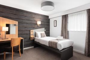 um quarto de hotel com uma cama e uma secretária em Caledonian Hotel 'A Bespoke Hotel’ em Ullapool