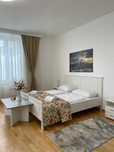 ウィーンにあるvienna city apartment 1の白いベッドルーム(ベッド1台、テーブル付)