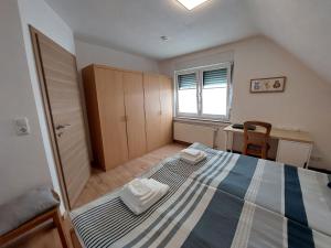 a bedroom with a bed and a desk and a window at Ferienwohnung im Elsetal in Plettenberg