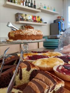 una tavola ricoperta con diversi tipi di torte e prodotti da forno di Hotel Villa Perazzini a Rimini