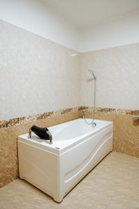 a white bath tub in a room with a wall at Thao Vy Hotel in Hai Phong