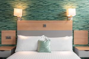 um quarto com uma cama com duas luzes por cima em Caledonian Hotel 'A Bespoke Hotel’ em Ullapool