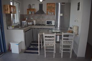 a kitchen with a table and two chairs and a refrigerator at Seaside resort- kallithea in Kallithéa