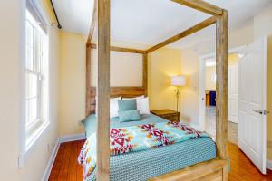 a bedroom with a wooden canopy bed in a room at RiverHouse in Ogunquit
