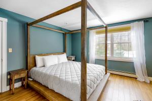 1 dormitorio con cama con dosel y paredes azules en RiverHouse en Ogunquit