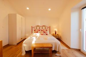 a bedroom with a large bed with a wooden headboard at A Casa do Maltês in Belver
