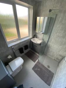a bathroom with a shower and a toilet and a sink at Corner Retreat Holiday Let Seahouses in Seahouses