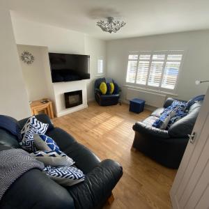 ein Wohnzimmer mit zwei Sofas und einem Fernseher in der Unterkunft Corner Retreat Holiday Let Seahouses in Seahouses