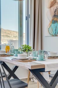 a dining room table with blue dishes on it at Villa Mare Syros in Finikas