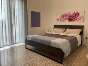 una camera da letto con un letto e un dipinto sul muro di il 64B - 10 minuti a piedi dal Policlinico San Matteo - a Pavia