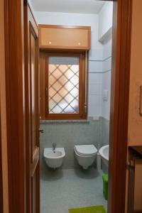 a bathroom with a toilet and a sink and a window at La Posada Roma in Rome