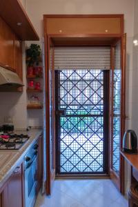 a kitchen with a sliding glass door with a window at La Posada Roma in Rome