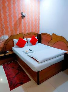 Una cama con almohadas rojas en una habitación. en Imperial Residency - Karol Bagh, en Nueva Delhi