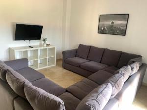 a living room with a couch and a flat screen tv at Villa Almenso in Seville