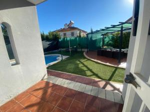 a view of a backyard with a pool and a house at Villa Almenso in Seville