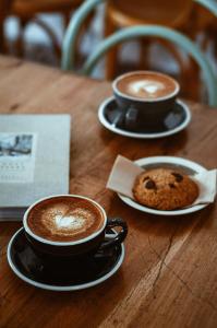 dos tazas de café y una galleta en una mesa en Imperial Residency - Karol Bagh, en Nueva Delhi