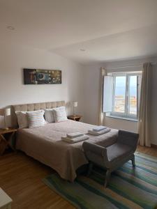 a bedroom with a large bed and a window at Casa Berlengas a Vista in Peniche