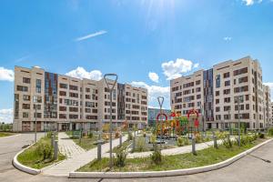 a playground in front of two large buildings at Апартаменты в ЖК Expo Residence C in Taldykolʼ