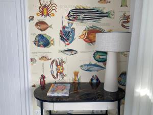 une table avec une lampe et un mur recouvert de poisson dans l'établissement GOLDEN MILE FRONT LINE BEACH RESORT, à Marbella