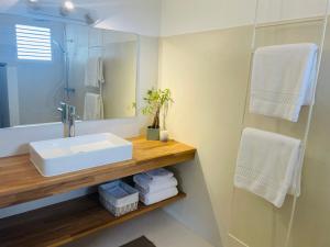 a bathroom with a sink and a mirror and towels at Le Bungalow & Car rental in Saint Barthelemy