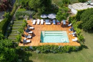 uma vista superior para uma piscina com cadeiras e guarda-sóis em Villa La Pergola Capri em Capri