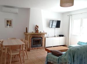 a living room with a table and a fireplace at Sa Vinya Casa de Campo in Es Cubells